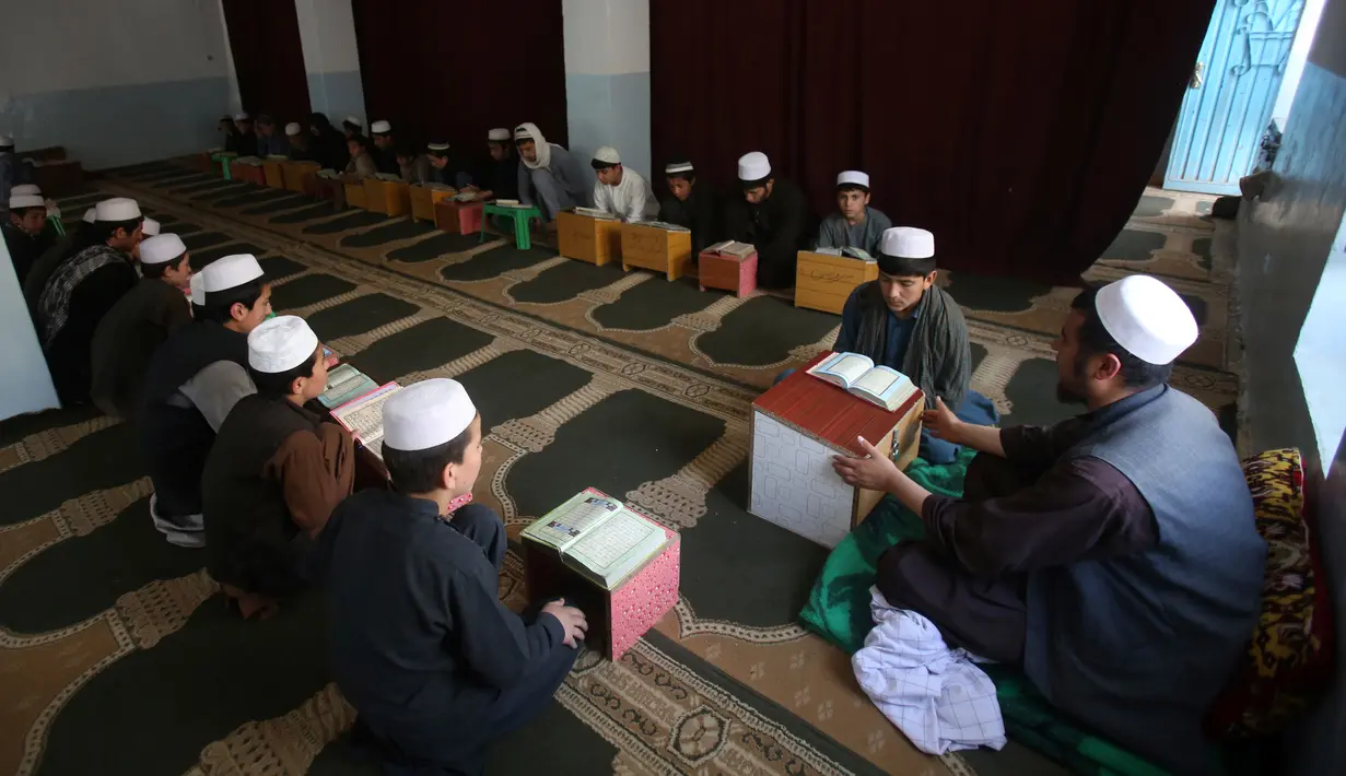 Suasana saat anak-anak belajar membaca Alquran di sebuah masjid di Kabul, Afghanistan, Senin, (21/5). Anak-anak Afghanistan lebih memperdalam Alquran di saat Ramadan. (AP Photo/Rahmat Gul)
