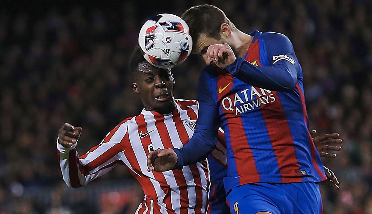 Bek Barcelona, Gerard Pique, duel udara dengan striker Athletic Bilbao, Inaki Williams. Bilbao sempat memperkecil kedudukan pada menit ke-51 menjadi 1-2 melalui gol dari Saborit. (EPA/Alejandro Garcia)