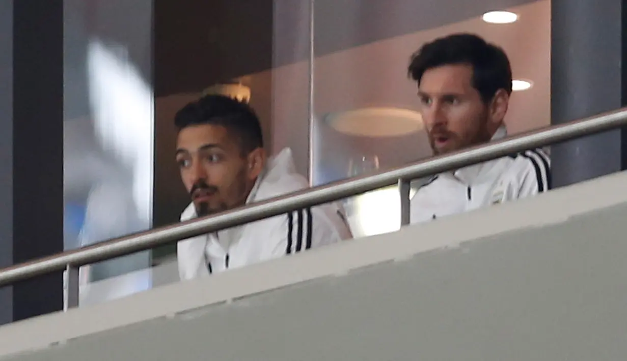 Kapten timnas Argentina, Lionel Messi menyaksikan laga persahabatan melawan timnas Spanyol di royal box Stadion Wanda Metropolitano, Selasa (27/3). Pada laga itu, Messi harus absen karena belum sepenuhnya pulih dari cedera hamstring. (AP/Francisco Seco)