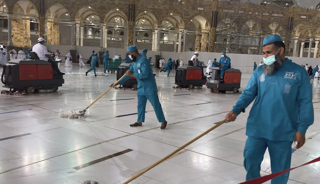 Pekerja mendisinfeksi halaman di Masjidil Haram di kota suci Muslim Mekkah, Arab Saudi, Minggu (17/10/2021). Tanda jaga jarak yang diperuntukkan untuk memandu orang berjaga jarak di dalam dan sekitar mesjid juga dihapus oleh para pekerja di Masjidil Haram. (AP Photo/Amr Nabil)