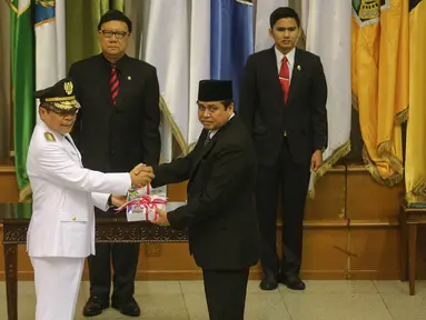 Mendagri Tjahjo Kumolo (tengah) menyaksikan serah terima berkas jabatan Penjabat Gubernur Jambi Irman (kiri) dengan Gubernur Jambi periode 2010-2015 Hasan Basri Agus di Kemendagri, Jakarta, Rabu (5/8/2015). (Liputan6.com/Faizal Fanani)