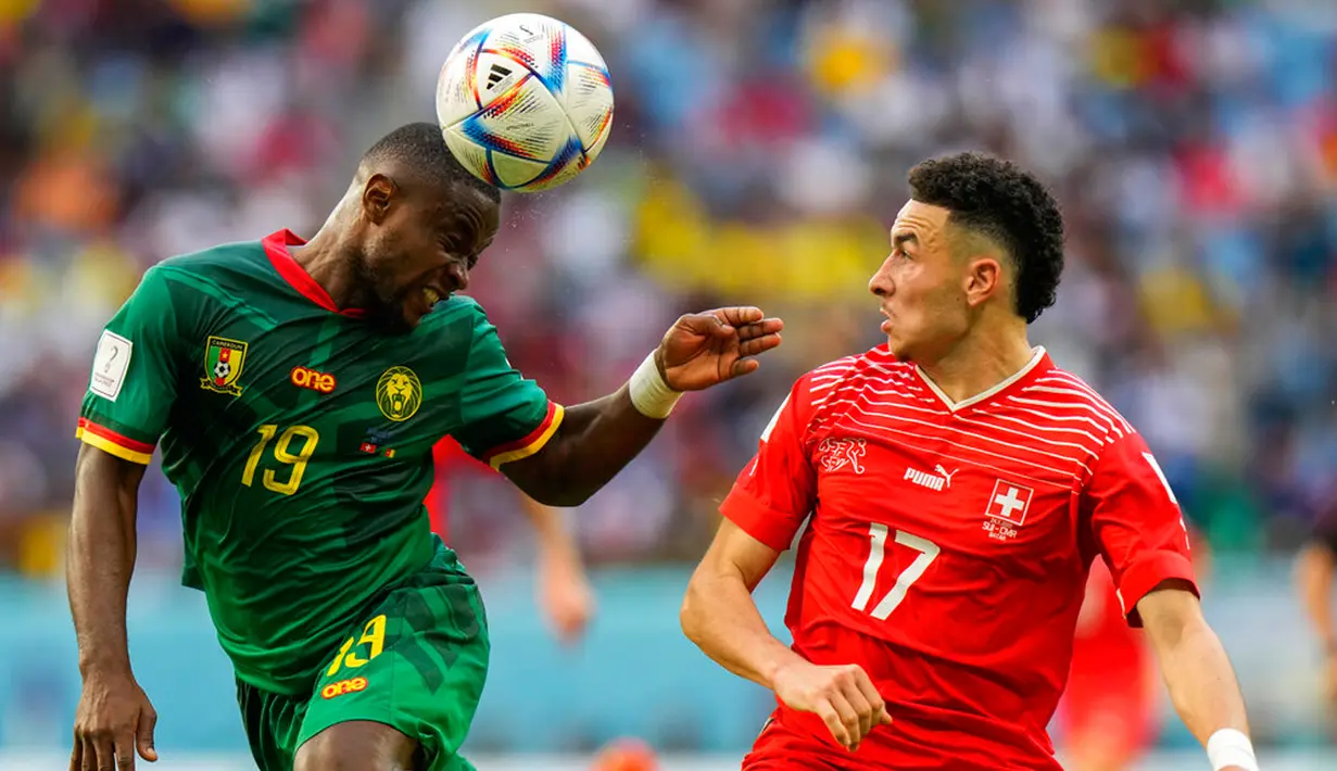 Pemain Kamerun Collins Fai (kiri) menyundul bola di sebelah pemain Swiss Ruben Vargas pada pertandingan sepak bola Grup G Piala Dunia 2022 di Stadion Al Janoub, Al Wakrah, Qatar, Kamis (24/11/2022). Swiss mengalahkan Kamerun dengan skor 1-0. (AP Photo/Luka Bruno)