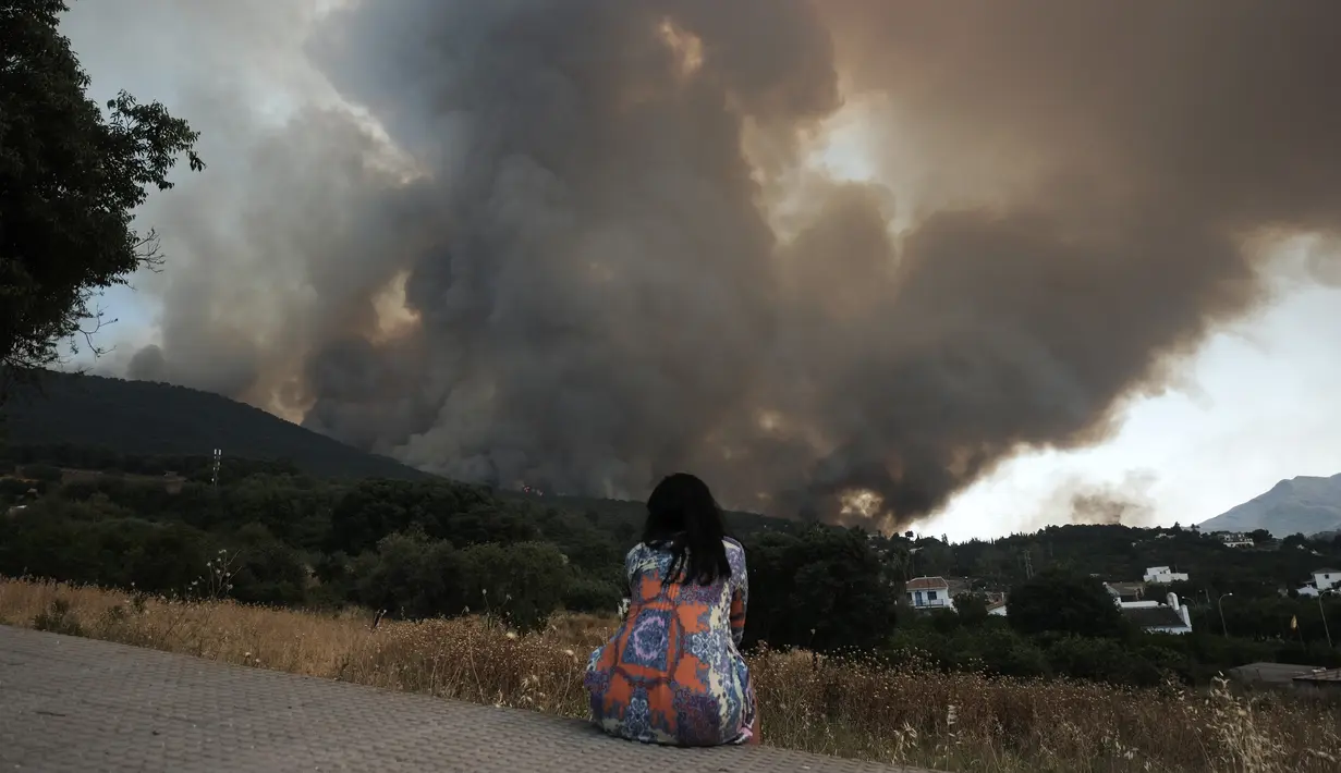 <p>Seorang perempuan menyaksikan api meluas di dekat daerah perumahan di Alhaurin de la Torre, Malaga, Spanyol, Sabtu (16/7/2022). Kebakaran hutan terus menyebar ke seluruh Spanyol ketika petugas pemadam kebakaran bekerja untuk mengendalikan api. (AP Photo/Gregorio Marrero)</p>
