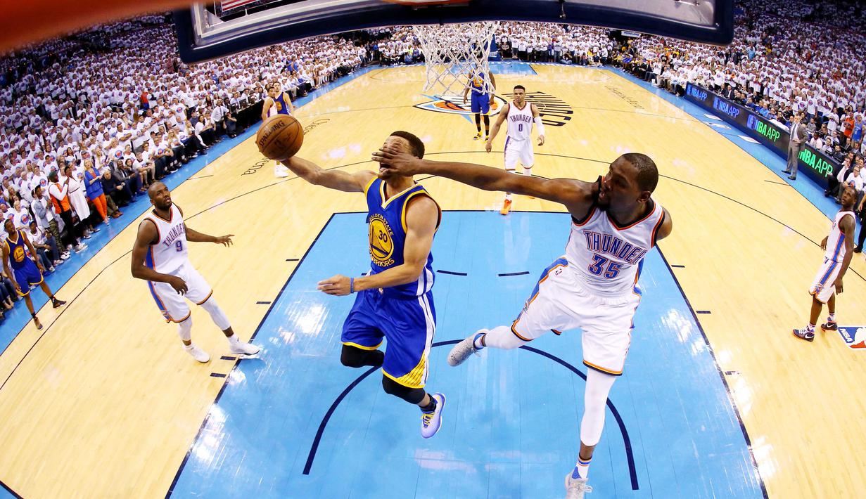 Pemain Warriors, Stephen Curry #30 dihadang pemain OKC Thunder, Kevin Durant #35 ketika melakukan lay up pada Final Wilayah Barat NBA Playoffs 2016 di Chesapeake Energy Arena, Oklahoma, (24/5/2016). OKC menang 118-94. (Ronald Martinez/Getty Images/AFP)
