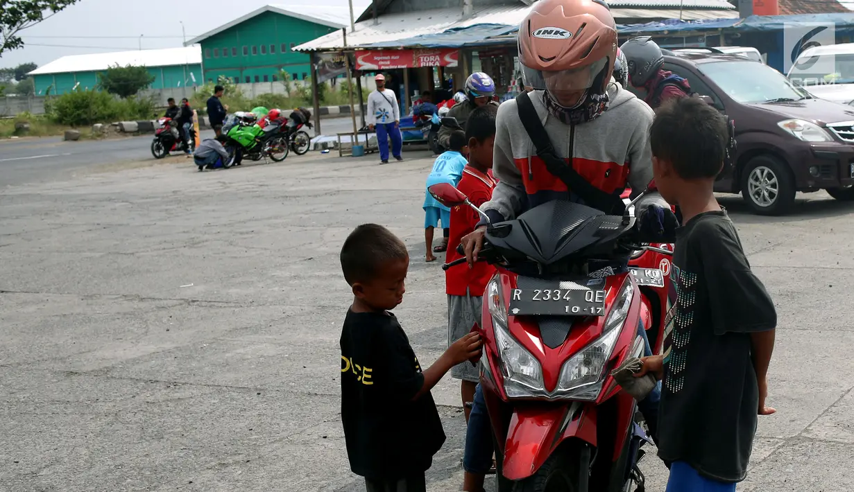Anak - anak di SPBU Tanjung Pantura - Brebes membersihakan motor pemudik dari Jakarta menuju kampung halamannya, Kamis (22/6). Memanfaatkan moment mudik ini anak - anak pantura mengais rejeki untuk lebaran 1438 H. (Liputan6.com/Johan Tallo)
