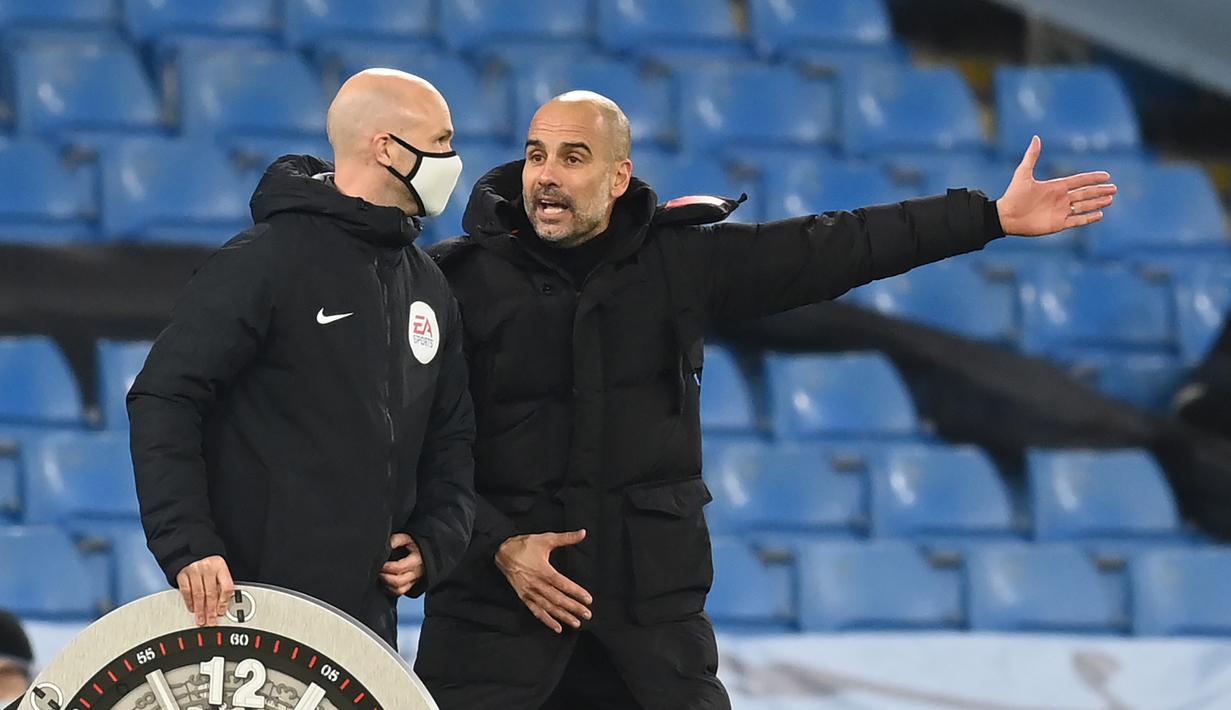 Pelatih Manchester City, Pep Guardiola, berbicara kepada ofisial wasit saat pertandingan melawan West Brom pada laga lanjutan Liga Inggris di Etihad Stadium, Rabu (16/12/2020). Pep Guardiola melakukan protes karena durasi injury time yang dianggap sedikit. (AFP/Clive Brunskill/pool)
