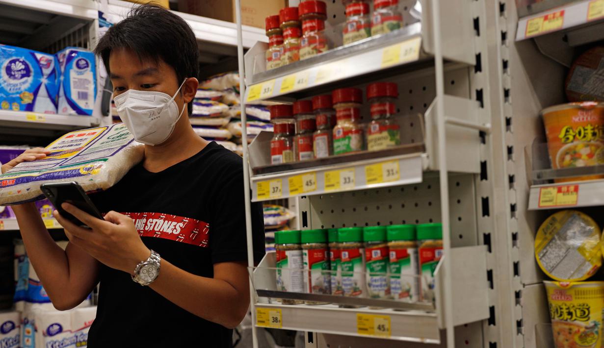 Seorang pelanggan memakai masker ketika berbelanja di sebuah supermarket di Hong Kong, Rabu (22/7/2020). Hong Kong telah mewajibkan penggunaan masker di semua area publik tertutup termasuk mal dan pasar seiring penambahan kasus baru harian Covid-19. (AP Photo/Kin Cheung)