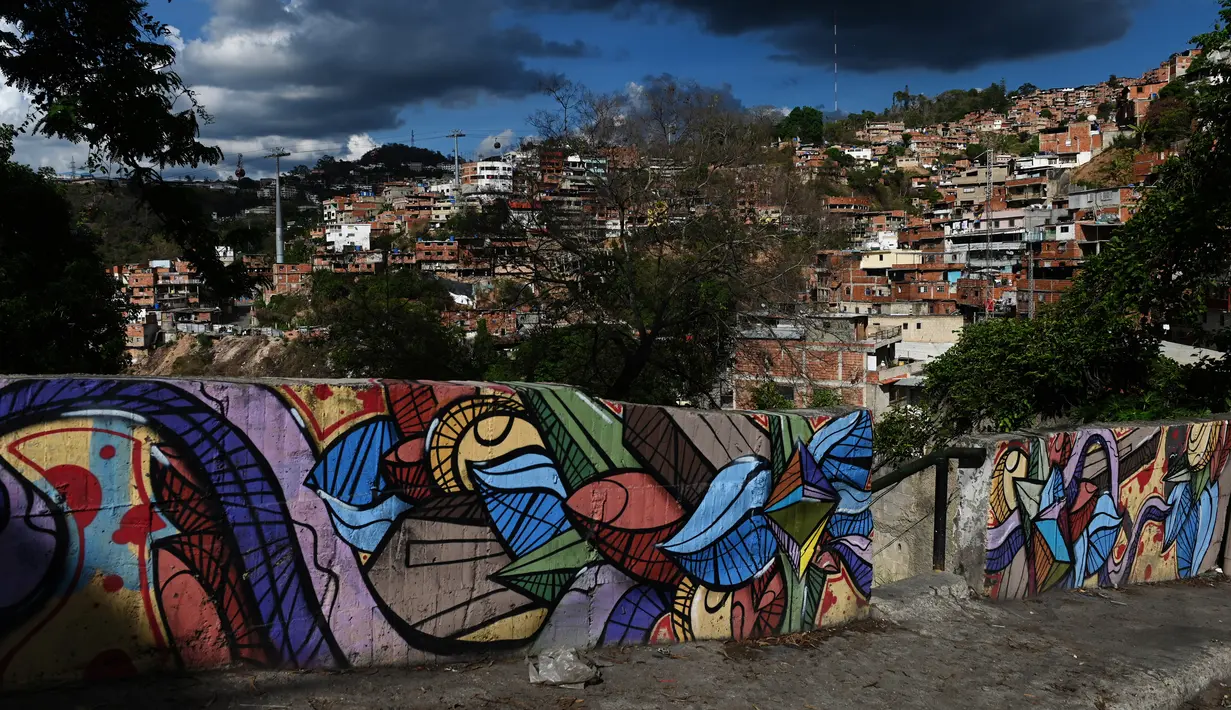 Warna-warni mural menghiasi tembok di permukiman kumuh Petare di Caracas pada 29 Mei 2019. Petare yang merupakan kawasan kumuh terbesar di Venezuela menjadi rumah bagi lebih dari 500.000 jiwa. (Photo by MARVIN RECINOS / AFP)