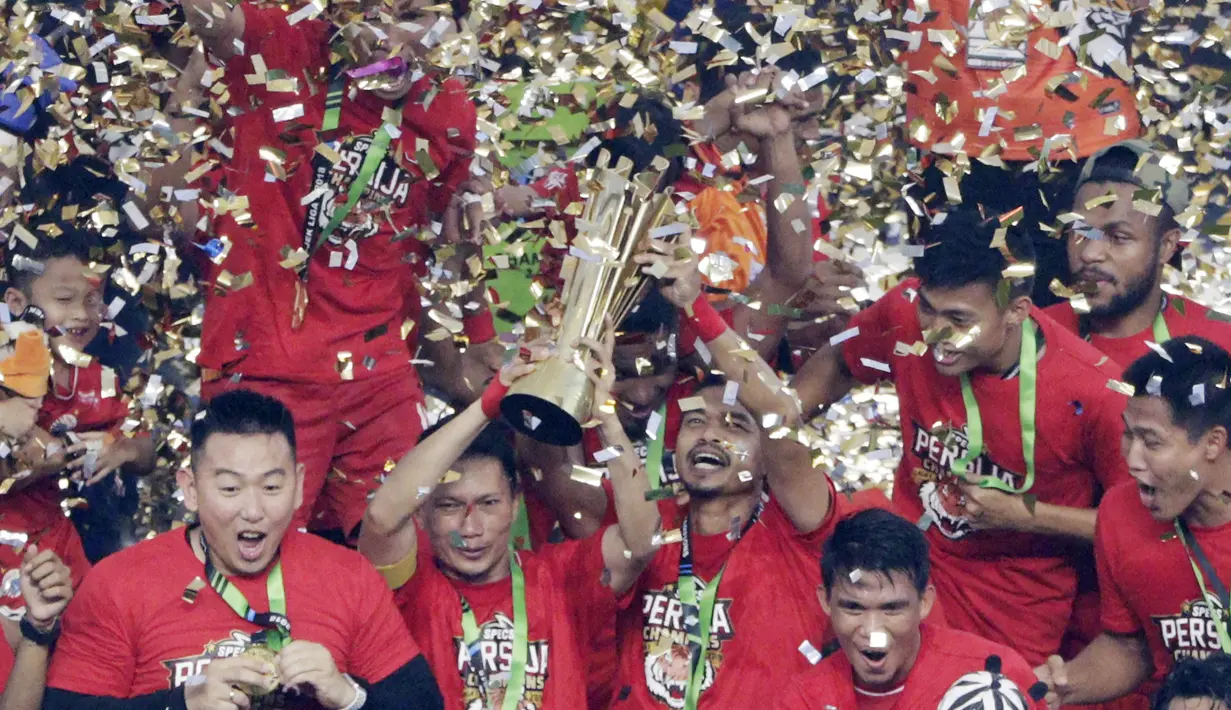 Pemain Persija Jakarta, Ismed Sofyan dan Bambang Pamungkas, mengangkat piala saat selebrasi juara Liga 1 di SUGBK, Jakarta, Minggu (09/12). Persija Jakarta menang 2-1 atas Mitra Kukar. (Bola.com/M Iqbal Ichsan)
