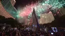 Pohon Natal setinggi 38 meter berdiri di salah satu pusat perbelanjaan di Jakarta (25/12/2015). Pesta kembang api menjadikan malam Natal di Jakarta semakin meriah. (AFP Photo/Adek Berry)