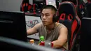 Seorang pria bermain game komputer di sebuah kafe internet di Beijing, China, Jumat (10/9/2021). Anak di bawah 18 tahun di China kini hanya diperbolehkan bermain game online satu jam di hari Jumat, Sabtu, Minggu, dan saat hari libur nasional. (GREG BAKER/AFP)