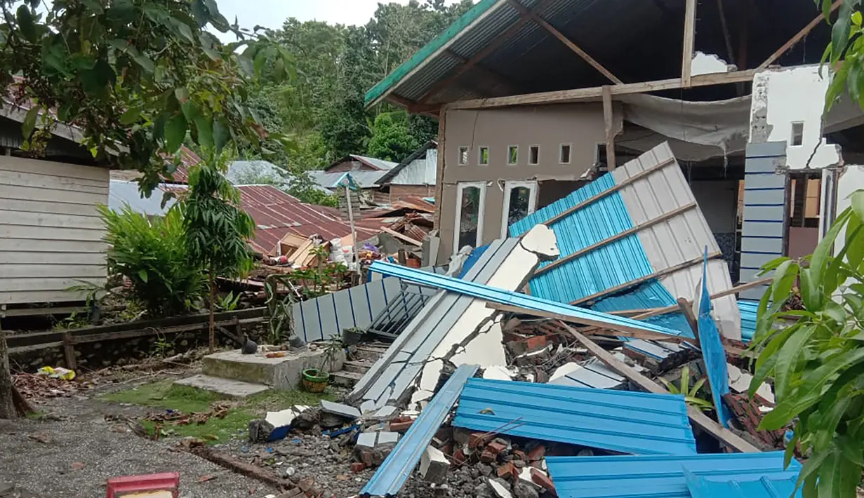 Kondisi bangunan rumah yang rusak di Majene sehari setelah gempa bumi magnitudo 6,2 mengguncang Sulawesi Barat, Sabtu (16/1/2021). Petugas Badan Penanggulangan Bencana Daerah (BPBD) masih mendata jumlah kerusakan dan korban akibat gempa bumi tersebut. (Aswan APRIANTO/AFP)