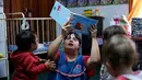 Seorang guru TK, Noelia Garella membacakan buku ke anak-anak saat bertugas di TK Jeromito, Cordoba, Argentina (24/10). Noelia 31 tahun merupakan penderita down syndrome pertama yang menjadi guru TK. (AFP Photo/Diego Lima)