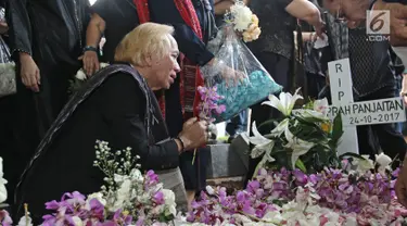 Personel Band Panbers, Asido Panjaitan menaruh bunga di pusaran makam Benny Panjaitan di TPU Menteng Pulo, Jakarta, Kamis (26/10). Pentolan band Panbers itu meninggal di usia 70 tahun akibat penyakit stroke yang dideritanya. (Liputan6.com/Herman Zakharia)