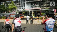 Sejumlah pesepeda mengambil gambar gedung utama Kejaksaan Agung RI yang terbakar di Jalan Sultan Hasanuddin, Jakarta Selatan, Minggu (23/8/2020).  Banyak warga yang memadati Jalan Hasanuddin untuk melihat langsung kondisi gedung Kejaksaan Agung yang hangus dilalap api. (Liputan6.com/Faizal Fanani)