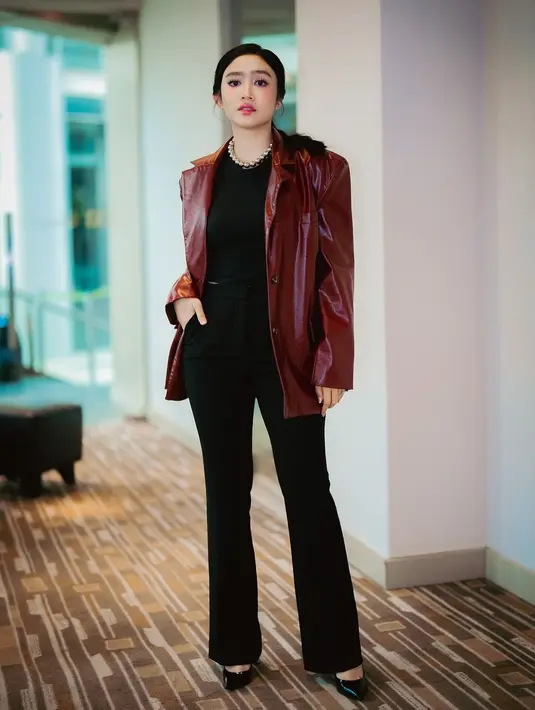 Di sini, Febby Rastanty mengenakan atasan, celana panjang, dan heels serba hitam, ditumpuknya dengan jaket kulit merah maroon. [Foto: Instagram/febbyrastanty]