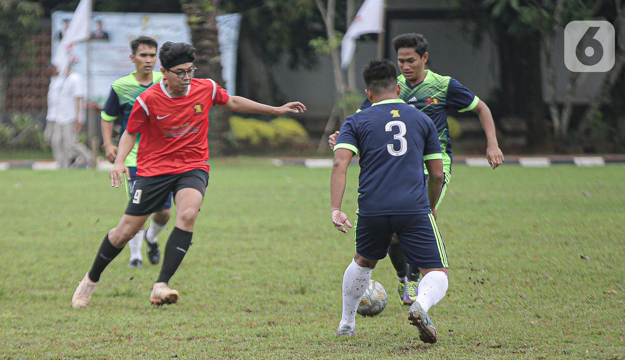 Pemain tim fraksi Gerinda berebut bola dengan pemain tim Gedung Taman DPR saat pertandingan dalam rangkaian HUT Gerindra ke-15 di Lapangan Sepak bola DPR RI, Jakarta, Selasa (31/1/2023). Sejumlah kegiatan dilaksanakan dalam rangkaian HUT Gerinda Ke-15 yang digelar sederhana dan tidak secara foya-foya. (Liputan6.com/Faizal Fanani)