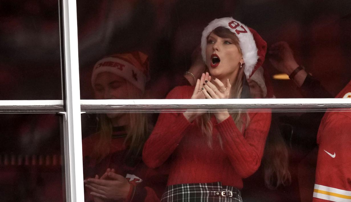 Taylor Swift terlihat menyaksikan pertandingan NFL (National Football League) antara Kansas City Chiefs melawan Las Vegas Raiders di Arrowhead Stadium, Kansas, Amerika Serikat, Selasa (26/12/2023) WIB. Ia datang langsung untuk menyaksikan sang kekasih, Travis Kelce yang bermain di Kansas City Chief. (AP Photo/Charlie Riedel)