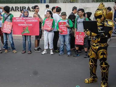 Seorang mengenakan cosplay menggelar aksi Tolak Reklamasi Pesisir saat Car Free Day (CFD) di kawasan Bundaran HI, Jakarta, Minggu (16/10). Mereka menyerukan stop reklamasi pesisir karena merusak lingkungan. (Liputan6.com/Faizal Fanani)