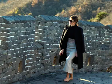 Ibu Negara AS, Melania Trump berjalan di sepanjang seksi Mutianyu, Tembok Besar China di Beijing, 10 November 2017. Mantan model itu Melania tampil dalam balutan kaus turtle neck, mantel, rok panjang dengan aksesori belt warna nude. (AP Photo/Ng Han Guan)