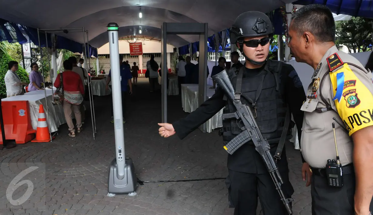Petugas melakukan koordinasi saat melakukan penjagaan di Gereja Katedral, Jakarta, Sabtu (24/12). Penjagaan dilakukan untuk menjaga kondusifitas agar acara Malam Misa Natal bisa berjalan lancar. (Liputan6.com/Helmi Afandi) 