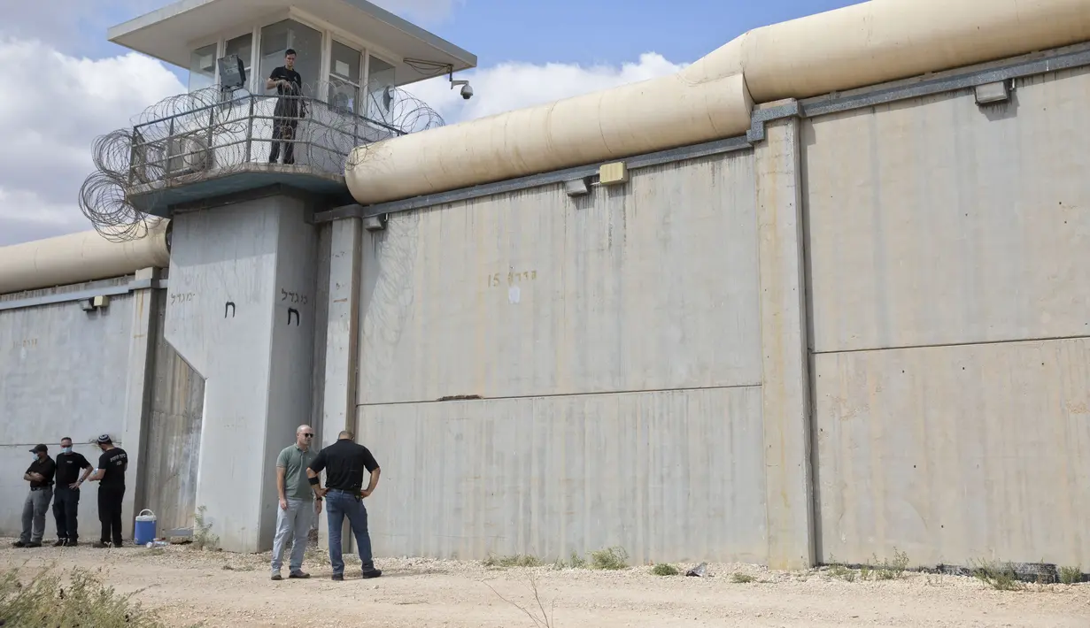 Petugas polisi dan penjaga penjara memeriksa lokasi pelarian penjara di luar penjara Gilboa di Israel utara, Senin (6/9/2021). (AP Photo/Sebastian Scheiner)