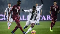 Gelandang Torino, Nicolas Nkoulou, berebut bola dengan gelandang Juventus, Blaise Matuidi, pada laga Serie A di Stadion Olympic, Turin, Sabtu (15/12). Torino kalah o-1 dari Juventus. (AFP/Marco Bertorello)