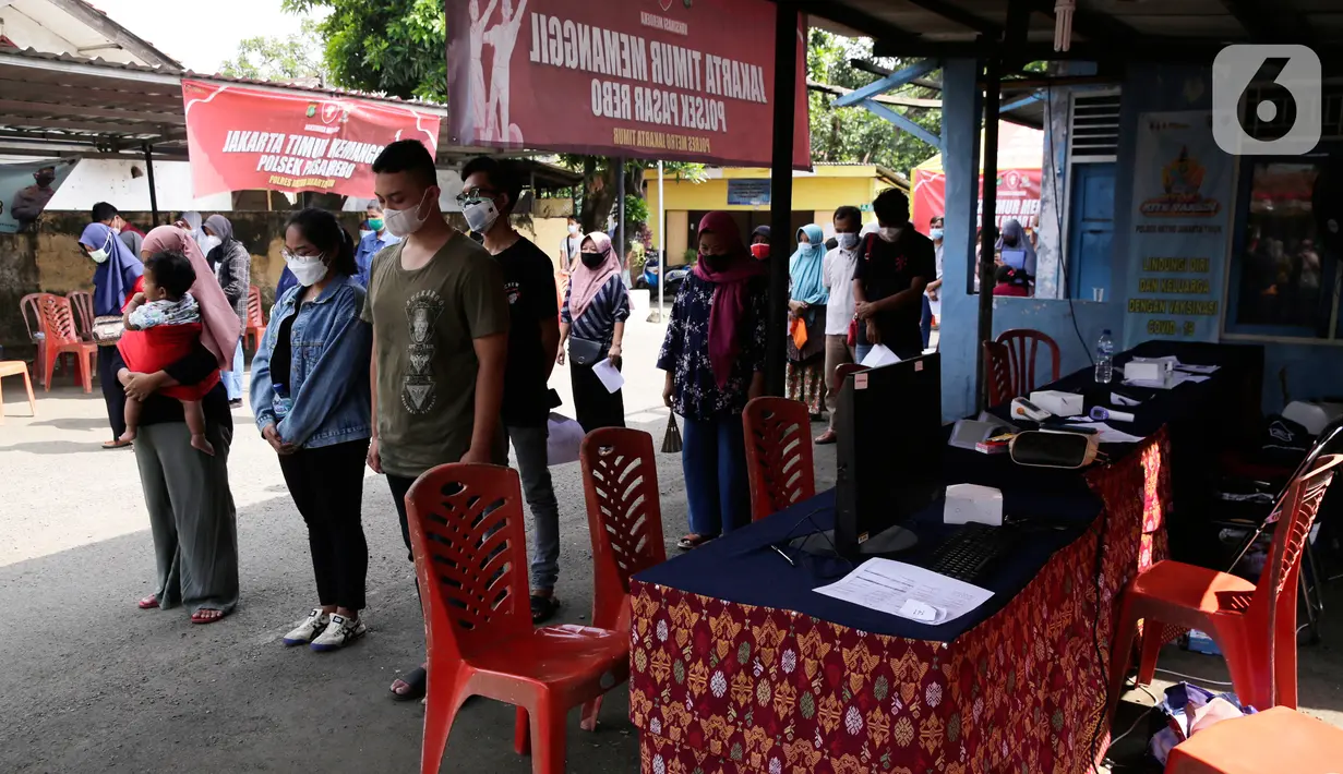 Ratusan masyarakat yang mengikuti vaksin Covid-19 berdiri mengheningkan cipta sejenak memperingati HUT ke-76 RI di Jakarta, Selasa (17/8/2021). Hal tersebut dilakukan untuk mengenang jasa para pahlawan dalam memperjuangkan Kemerdekan Republik Indonesia. (Liputan6.com/Angga Yuniar)