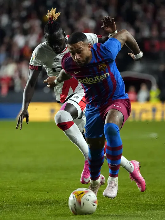 Pemain Barcelona Memphis Depay (kanan) berebut bola dengan pemain Rayo Vallecano Pathe Ciss pada pertandingan La Liga Spanyol di Stadion Vallecas, Madrid, Spanyol, 27 Oktober 2021. Barcelona kalah 0-1. (AP Photo/Manu Fernandez)