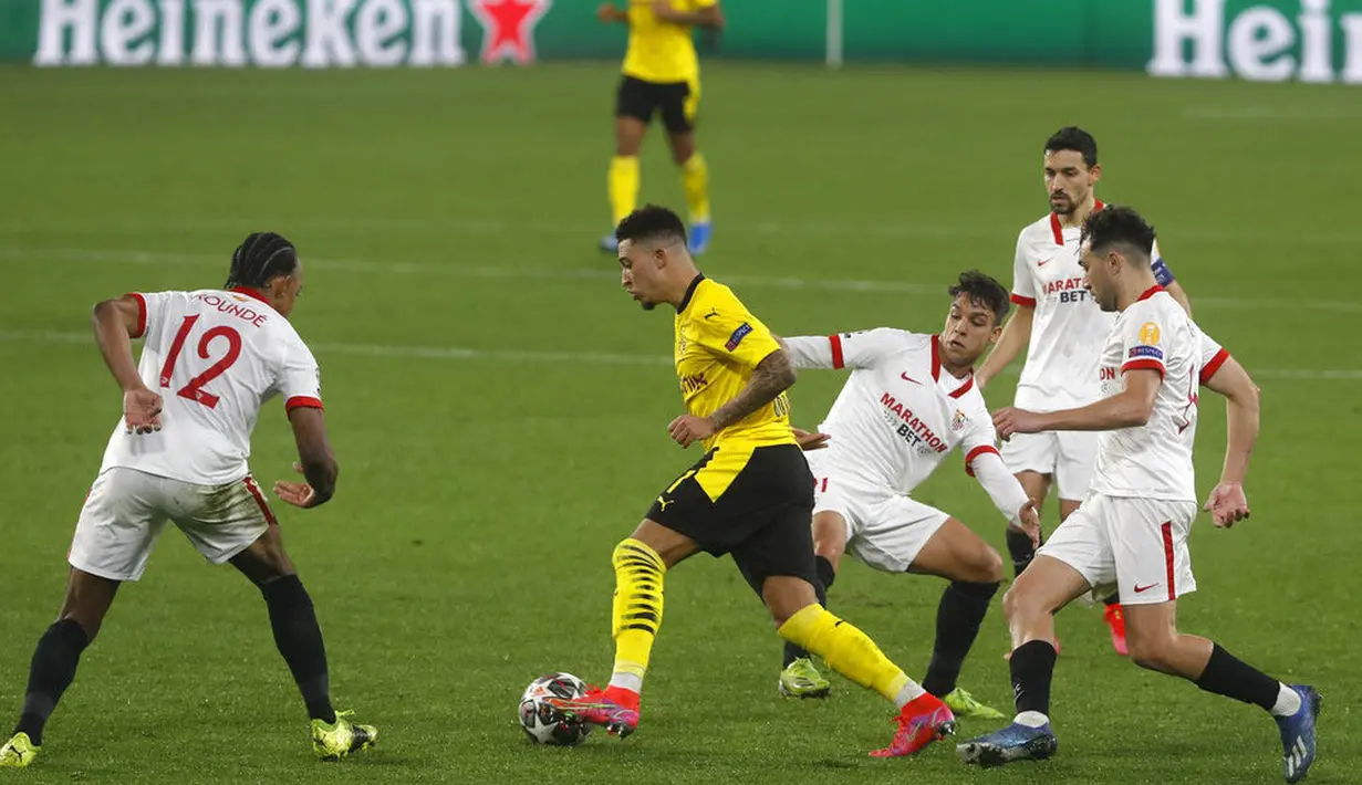 Pemain Borussia Dortmund, Jadon Sancho, melewati pemain Sevilla, Nemanja Gudelj, pada laga Liga Champions di Stadion Ramon Sanchez Pizjuan, Kamis (18/2/2021). Dortmund menang dengan skor 2-3. (AP/Angel Fernandez)