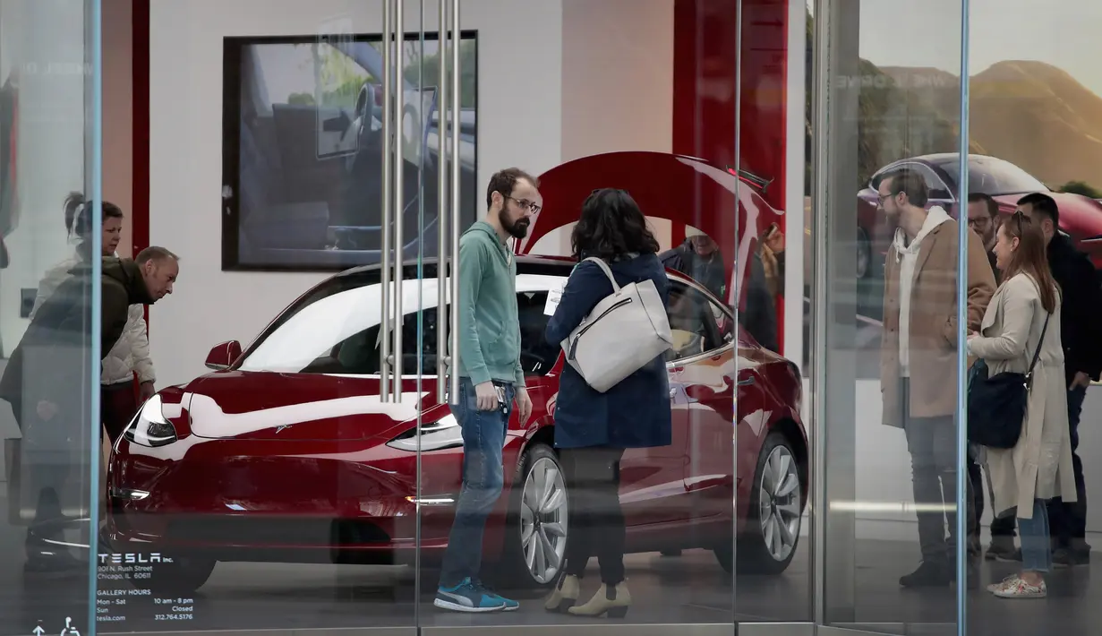 Pengunjung melihat mobil Tesla model 3 di sebuah dealer di Chicago, Illinois (30/3). Kematian tersebut merupakan yang pertama kali terjadi dalam kendaraan Tesla yang beroperasi dalam kondisi autopilot. (Scott Olson / Getty Images / AFP)