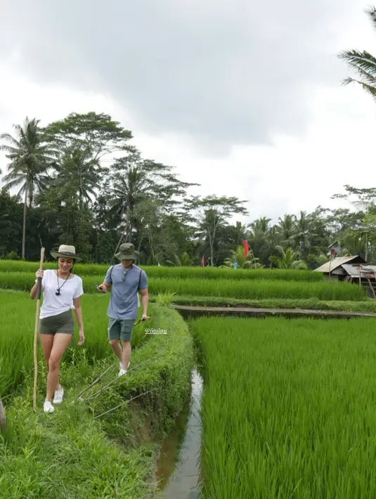 Nay dan kekasih mengenakan busana ala petualang agar bisa leluasa menjelajah sawah yang dialiri air jernih. (Instagram @naymirdad)