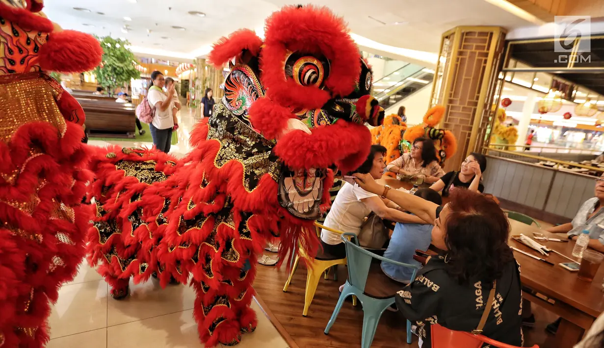 Pengunjung memberikan angpao saat parade barongsai pada perayaan Cap Go Meh di Pluit Village, Jakarta Utara, Jumat (02/3). Parade yang mengelilingi Mall sepanjang 3 Km dimulai dari lobi utama. (Liputan6.com/Fery  Pradolo)