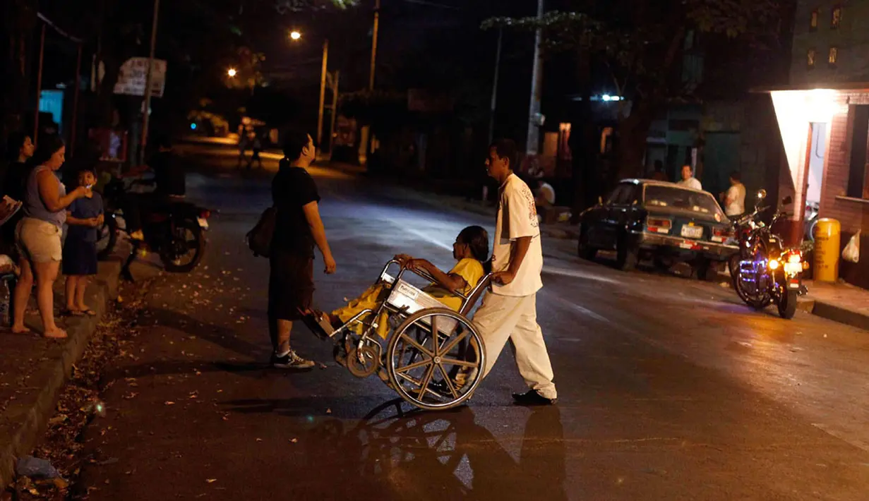 Seorang wanita yang berada di atas kursi roda terlihat dievakuasi setelah gempa bumi berkekuatan 4,9 skala richter kembali mengguncang Managua, Minggu malam (13/4/2014) waktu setempat. (REUTERS/Jorge Cabrera)