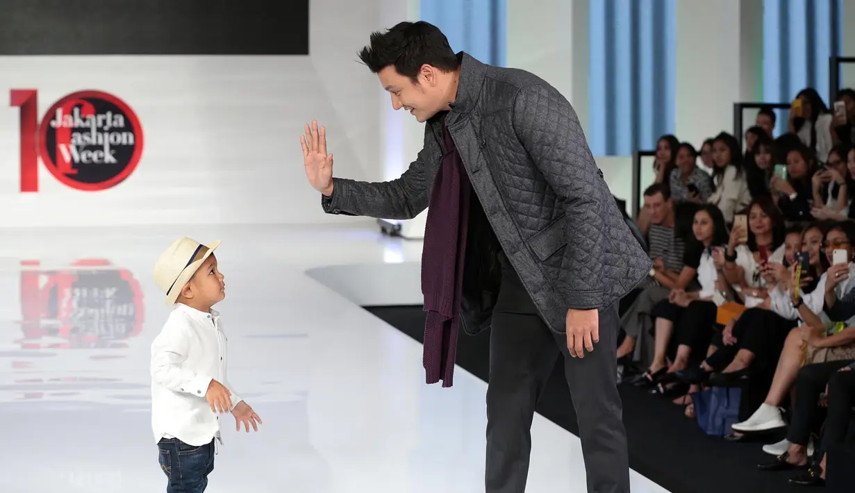Untuk pertama kalinya anak pasangan Titi Kamal dan Christian Sugiono melenggang di atas panggung catwalk. Arjuna Zayan Sugiono berjalan diatas catwalk bersama dengan ayahnya. (Deki Prayoga/Bintang.com)