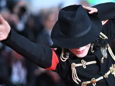 Pria berpenampilan Michael Jackson berpose setibanya di karpet merah  pemutaran film Solo: A Star Wars Story pada Festival Film Cannes, Prancis, Selasa (15/5). Kehadiran pria mirip mendiang raja musik pop dunia itu mengundang perhatian. (AFP/LOIC VENANCE)