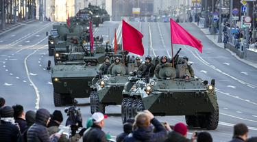 Penonton menyaksikan kendaraan lapis baja Rusia yang dihiasi bendera merah di sepanjang jalan Tverskaya menuju Lapangan Merah untuk menghadiri latihan parade militer Hari Kemenangan di Moskow, Rusia, Rabu (4/5/2022). Pawai akan berlangsung pada Mei 9 untuk merayakan 77 tahun kemenangan dalam Perang Dunia II. (Foto AP/Alexander Zemlanichenko)