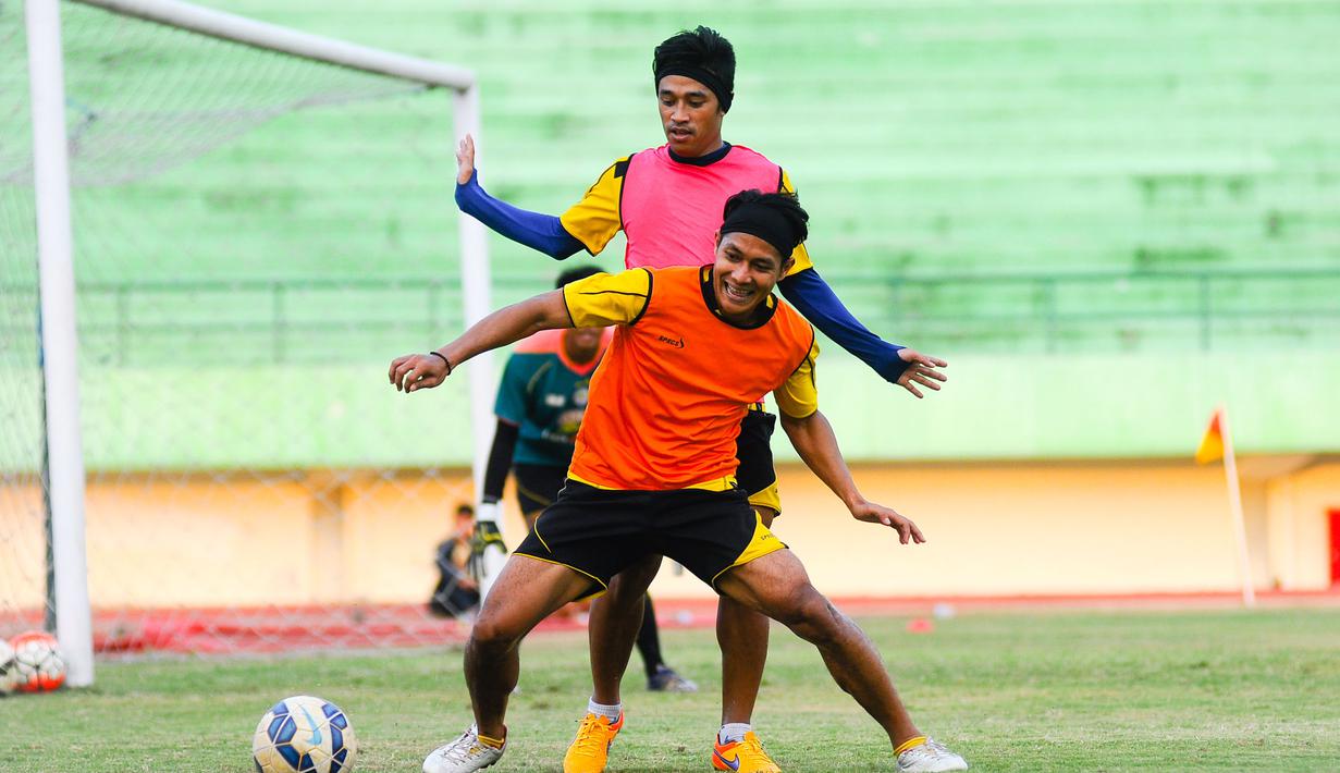 Purwaka dan Beny Wahyudi berebut bola saat latihan Arema Cronus di Stadion Manahan, Solo, Jumat (9/10/2015). (Bola.com/Kevin Setiawan)