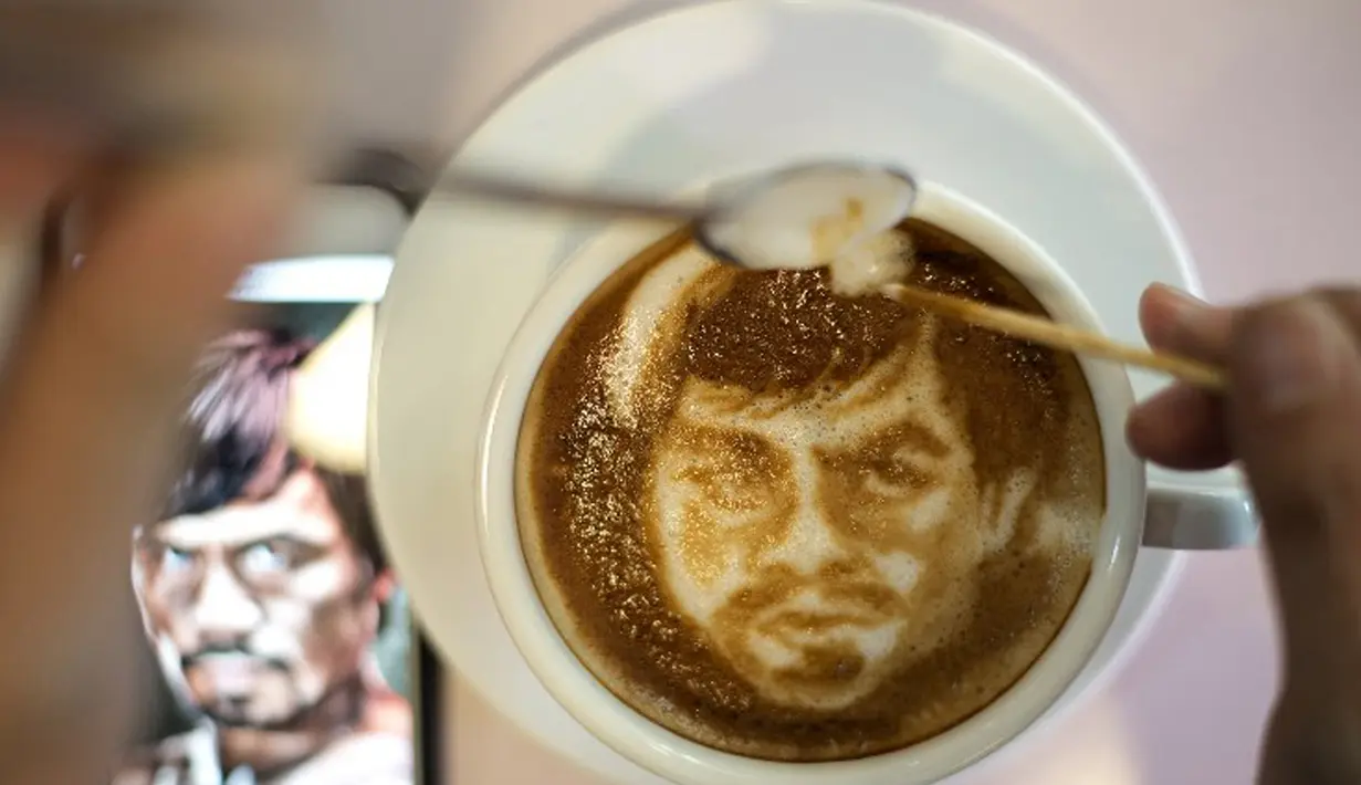 Zach Yonzon saat melukis Manny Pacquiao (Filipina) pada busa kopi susu latte di Manila, Filipina, Kamis (23/4/2015). Floyd Mayweather Jr dan Manny Pacquiao akan bertarung di MGM Grand Arena, Las Vegas, AS pada 2 Mei mendatang. (AFP PHOTO/Noel Celis)