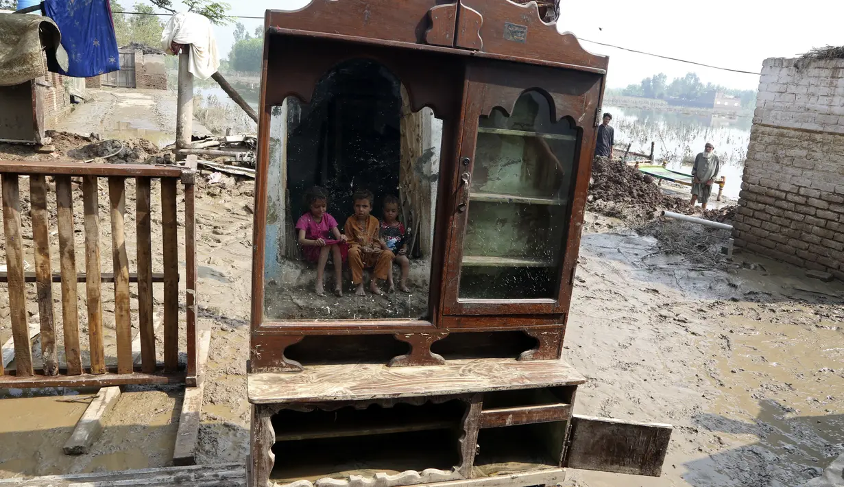 Anak-anak tercermin dalam cermin di dekat rumah mereka yang terkena banjir, di Charsadda, Pakistan, Rabu (31/8/2022). Para pejabat di Pakistan menyampaikan kekhawatiran Rabu atas penyebaran penyakit yang ditularkan melalui air di antara ribuan korban banjir saat air banjir dari hujan monsun yang kuat mulai surut di banyak bagian negara. (AP Photo/Fareed Khan)