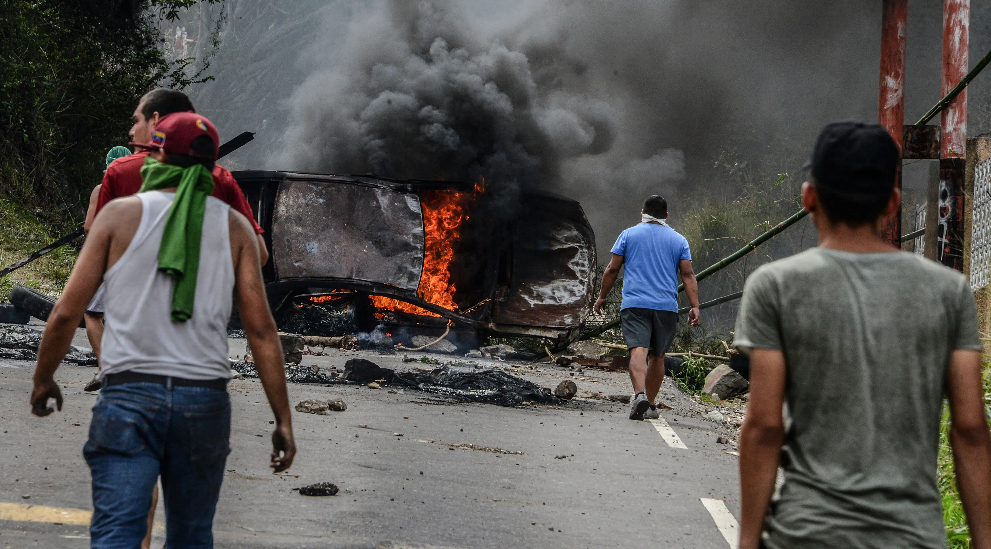 Demonstran dari oposisi Venezuela membuat barikade dengan membakar mobil saat menggelar aksinya menentang Presiden Nicolas Maduro di Caracas, Venezuela (24/4). (AFP/Federico Parra)