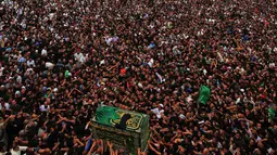 Ribuan umat Syiah Irak mengiringi peti jenazah yang menyimbolkan Musa al-Kadhim di Kadhimiya, Irak (12/4). Imam Musa al-Kadhim adalah imam ketujuh dari 12 imam Syiah yang meninggal pada 799. (AFP Photo/Ahmad Al-Rubaye)