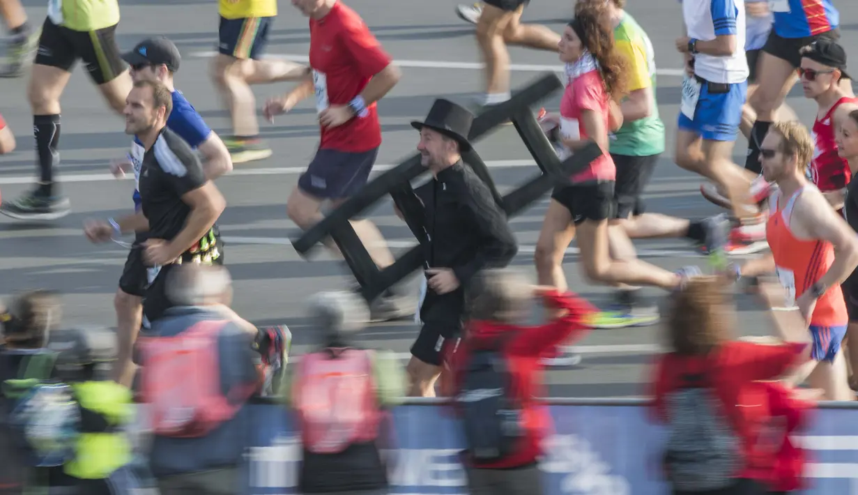 Seorang peserta mengenakan pakaian penyapu cerobong ikut memeriahkan ajang Berlin Maraton ke- 43 di Berlin (25/9/2016). (AFP/John Macdougall)