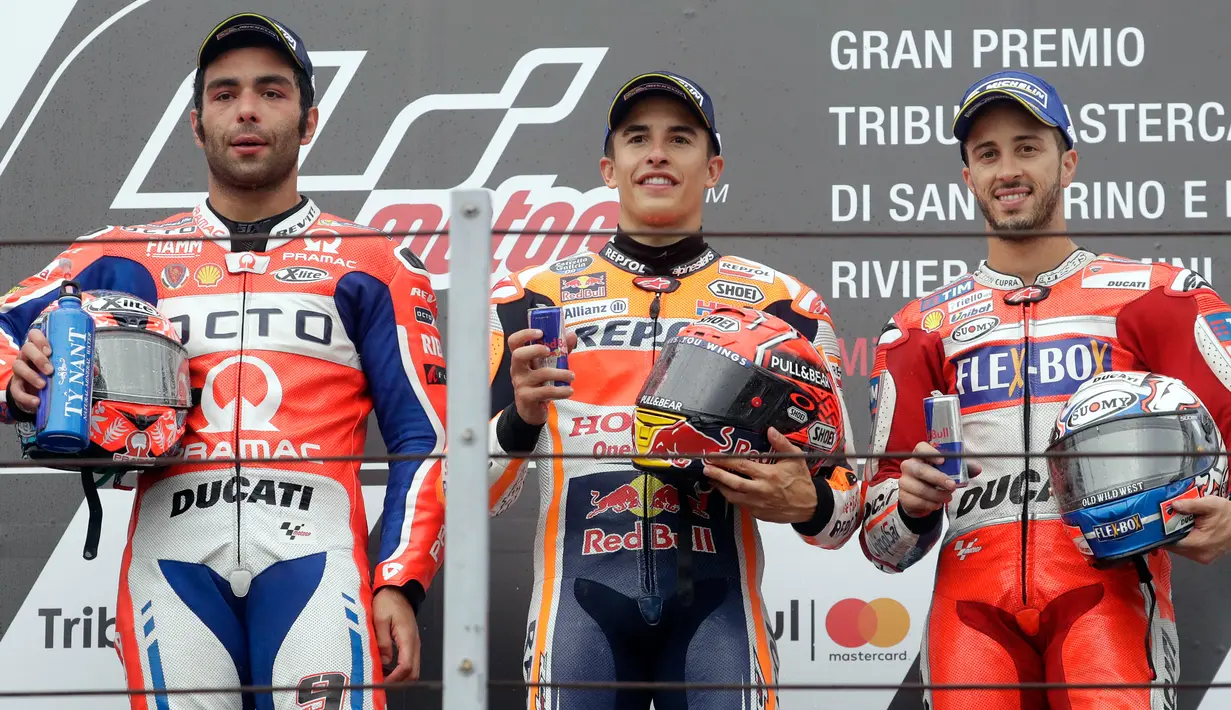 Pembalap Repsol Honda, Marc Marquez berpose dengan pembalap tim Octo Pramac Racing, Danilo Petrucci dan pembalap Ducati, Andrea Dovizioso di atas podium MotoGP San Marino 2017 di Italia, Minggu (10/9). (AP Photo/Antonio Calanni)