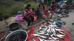 Etnis Vietnam menjual ikan di sepanjang trotoar dekat desa Prek Pnov di Phnom Penh, Kamboja, Kamis (5/8/2021). Prek Pnov terkenal dengan peternakan ikannya dan memasok banyak pasar di Phnom Penh. (AP Photo/Heng Sinith)