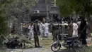 Petugas polisi, penyelidik, dan petugas penyelamat berkumpul di lokasi ledakan, di Lahore, Pakistan, Rabu (23/6/2021).  Seorang saksi mata mengatakan bahwa seorang  tak dikenal memarkir sepeda motor di dekat rumah yang kemudian meledak. (AP Photo/K.M. Chaudary)