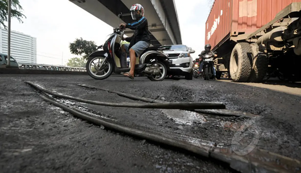 Jalan RE Martadinata, Jakarta, mengalami kerusakan akibat banjir yang merendam sejumlah wilayah Jakarta beberapa waktu lalu, Senin (16/2/2015). (Liputan6.com/Faizal Fanani)