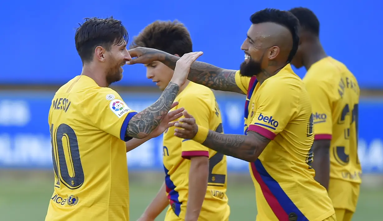 Pemain Barcelona, Lionel Messi dan Arturo Vidal merayakan gol ke gawang Alaves pada laga La Liga di Stadion Mendizorroza, Minggu (19/7/2020). Barcelona menang dengan skor 5-0. (AFP/Ander Gillenea)