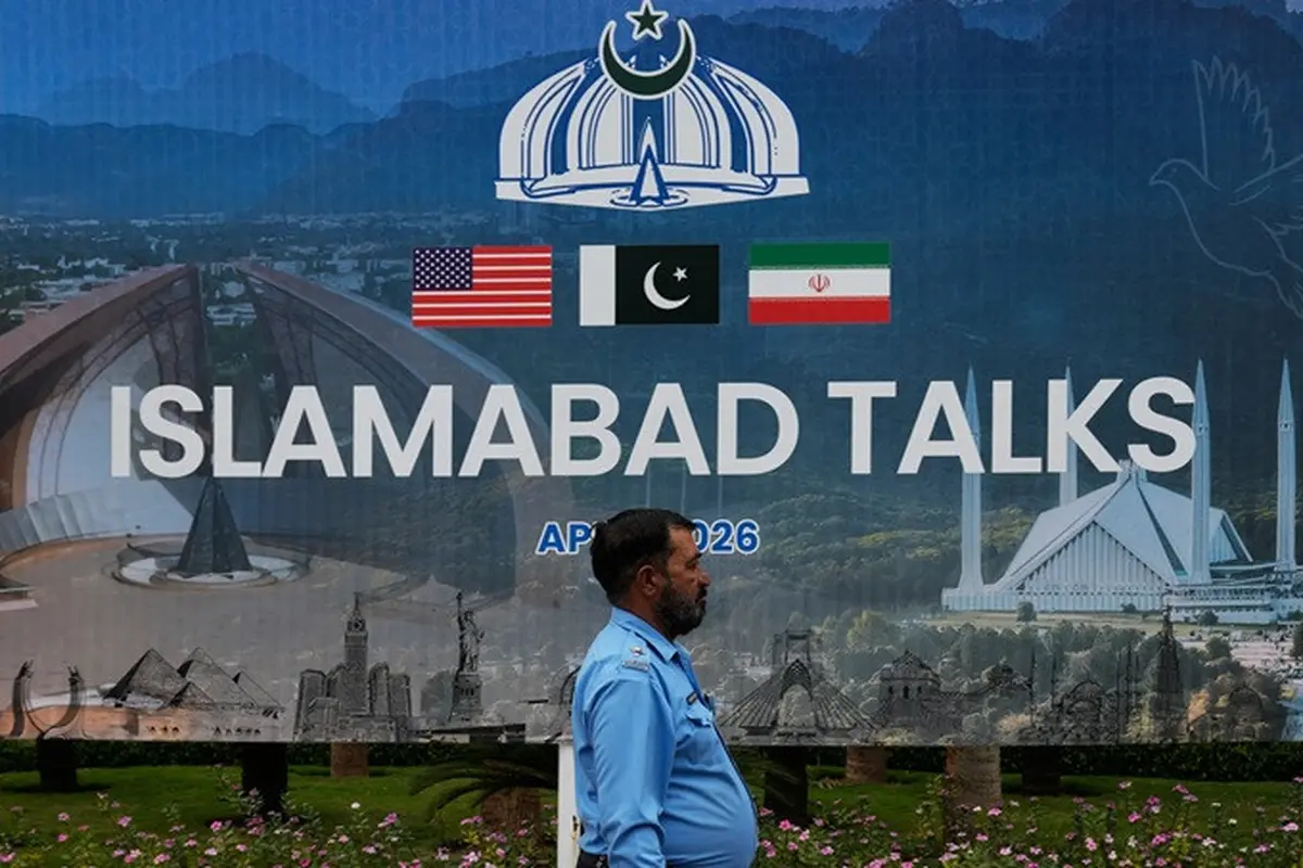 Seorang petugas polisi melintas di depan papan reklame tentang negosiasi antara Amerika Serikat dan Iran, di Islamabad, Pakistan, Sabtu (11/4/2026).
