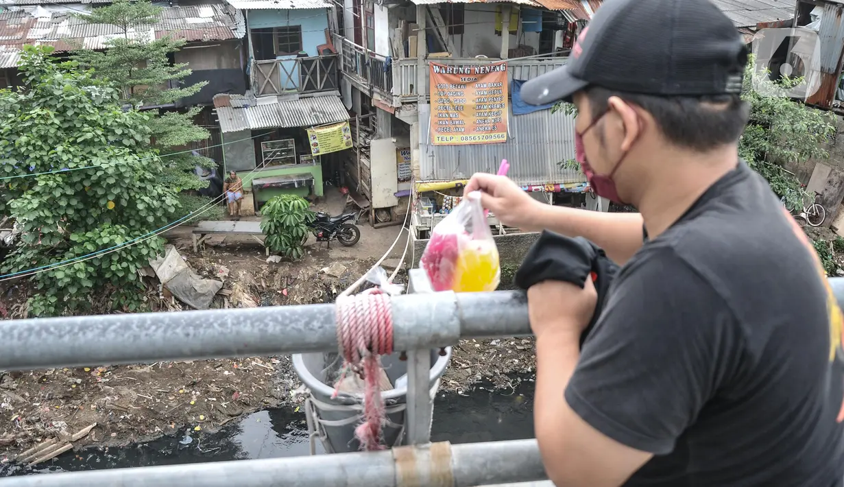 Pembeli saat mengambil makanan yang dibeli di warung kerek di Kuningan Barat, Mampang Prapatan, Jakarta Selatan, Rabu (25/5/2022). Untuk omzet warung kerek saat ini mencapai Rp1 juta-Rp2 juta per hari dari menjual berbagai menu makan siang seperti nasi rames dan ayam geprek. (merdeka.com/Iqbal S Nugroho)